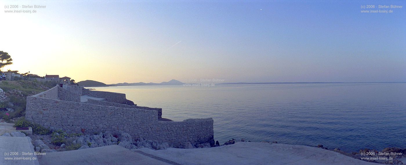Panoramablick an der Küste am Kurbad in Veli Losinj (linke Bildhälfte)<br>im Hintergrund (ganz links außen) ist der Osorscica zu sehen